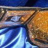 This big gold heavyweight championship belt is awesome with the design and metal work. This has a beautiful embossed or tooled leather strap.